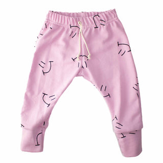 Flat lay of hot pink sweatpants with all-over smiley face design by My Mini Explorer, perfect for adventurous kids. Outdoor-inspired style for everyday play and exploration.