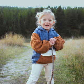 Young explorer wearing My Mini Explorer quarter zip sherpa hoodie outdoors, designed for warmth with a 100% polyester shell and cotton lining, perfect for cool weather adventures