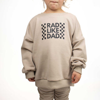 Child wearing Rad Like Dad crewneck sweatshirt in beige, showcasing baggy style. Handmade in Montana near Glacier National Park. 