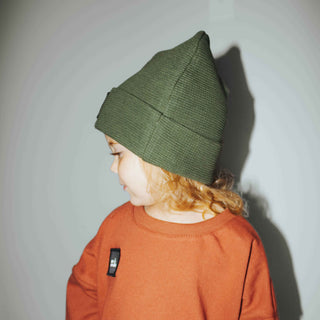 Forest green colored thermal fabric beanie with a patch saying "mini explorer".