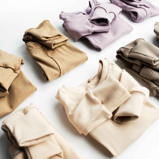 Various colors of ribbed pajamas including elderberry, parchment, mushroom, and barley.