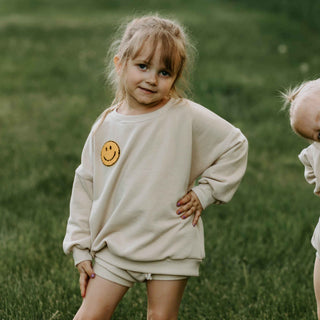 Organic cotton parchment crewneck for baby - youth with a smiley patch added. 
